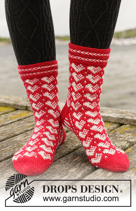 Holiday Hearts / DROPS Extra 0-1464 - Strikkede sokker med hjerter i DROPS Fabel. Arbeidet strikkes ovenfra og ned med latvisk flette og nordisk mønster. Størrelse 35 - 43. Tema: Jul.