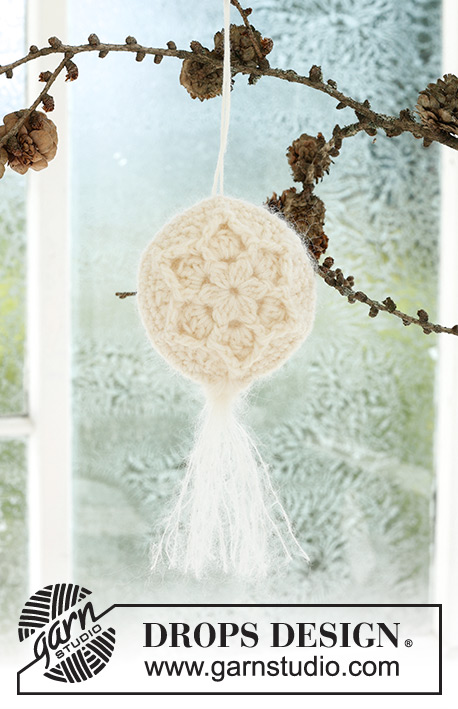 Frozen Flowers / DROPS Extra 0-1589 - Horgolt karácsonyi gömb DROPS Baby Merino és DROPS Kid Silk fonalól. A darabot két részben horgoljuk, körben, közepéről kifelé haladva, relief-mintával, csillaggal és bojttal. Téma: Karácsony
