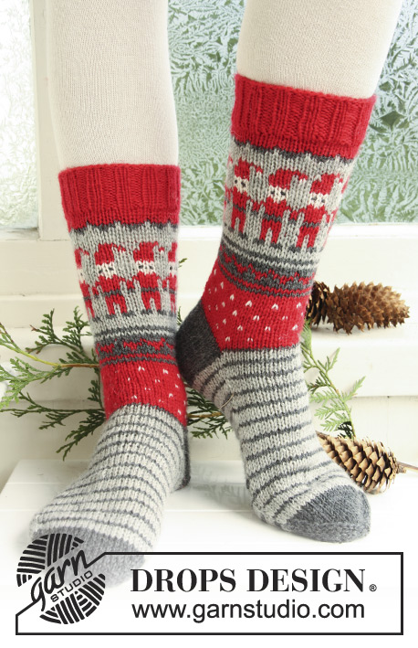 Dancing Elves / DROPS Extra 0-722 - Strikkede sokker til børn og voksen i DROPS Karisma. Arbejdet strikkes med mønster med julenisser, striber og hjerter. Størrelse 32-43. Tema: Jul