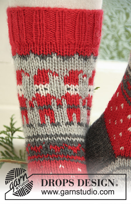 Dancing Elves / DROPS Extra 0-722 - Strikkede sokker til børn og voksen i DROPS Karisma. Arbejdet strikkes med mønster med julenisser, striber og hjerter. Størrelse 32-43. Tema: Jul