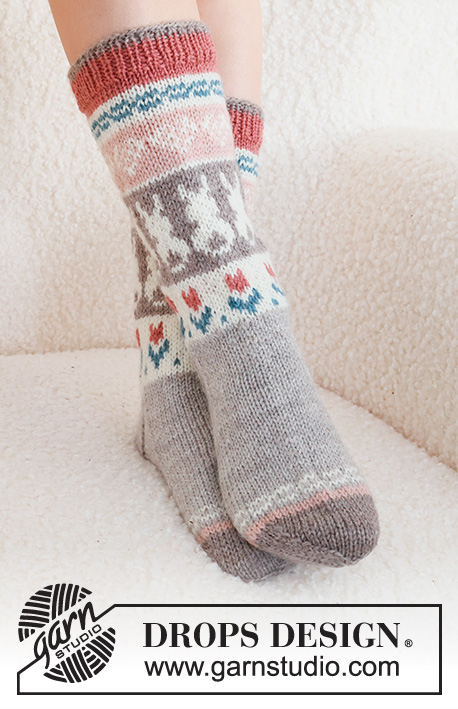 Dancing Bunny Socks / DROPS 229-34 - Kötött Drops zokni DROPS Karisma fonalból. A darabot fentről lefelé haladva készítjük, harisnyakötéssel, színes mintával szívvel, húsvéti nyuszival és virággal.
35 - 46 -os méretben. Téma: Húsvét