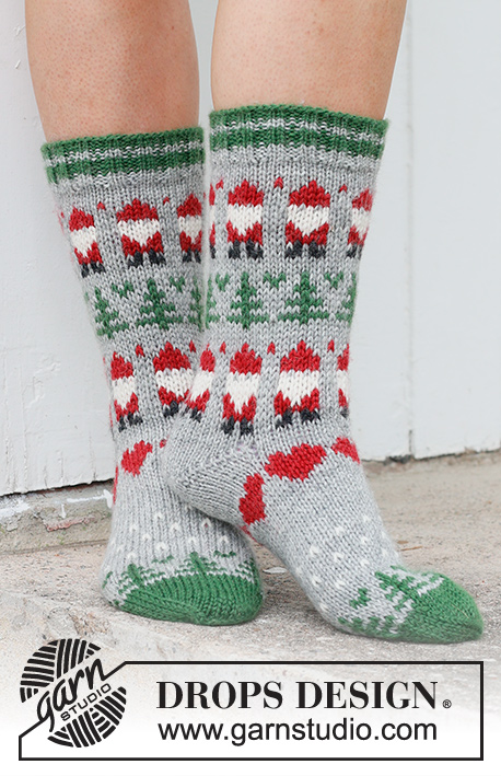 Christmas Time Socks / DROPS 234-63 - Strikkede sokker i DROPS Karisma. Arbeidet strikkes ovenfra og ned i flerfarget mønster med nisse, grantre og hjerte. Størrelse 35 – 43. Tema: Jul.