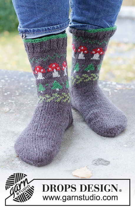 Mushroom Season Socks / DROPS 246-43 - Stickade halvlånga sockor till herr i DROPS Karisma. Arbetet stickas uppifrån och ner i slätstickning med flerfärgat mönster med svamp och gran. Storlek 35 – 46. Tema: Jul.