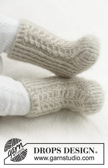 Mini Snow Boots / DROPS Baby 31-25 - Gebreide sokken met kabels en boordsteek voor baby. Maat 1 maand - 4 jaar Het werk wordt gebreid in DROPS Puna.