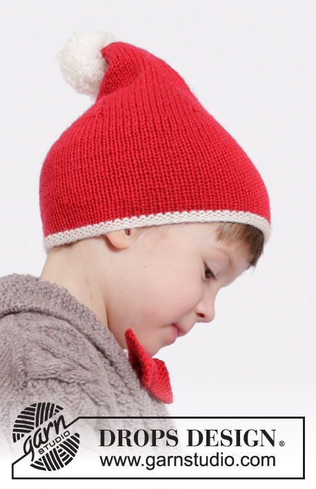 Charming Cooper Santa Hat / DROPS Children 26-18 - Completo formato da: Cappello di Natale con pompom e fiocco in DROPS Karisma o DROPS Lima. Taglie: 3 - 12 anni.