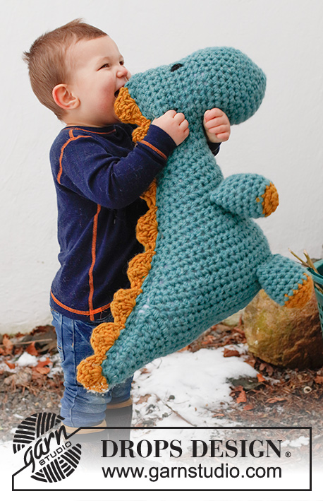 Dino Cuddles / DROPS Children 41-29 - Gehaakte Dino (T-Rex) in 2 draden DROPS Snow. Het werk wordt gehaakt vanaf de neus tot de staart met 1 naad. Thema: Zacht speelgoed.