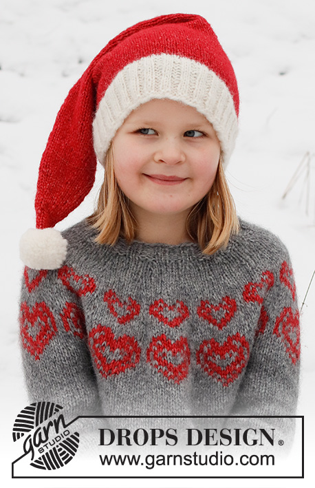 Merry Hearts / DROPS Children 41-3 - Dziecięcy sweter / świąteczny sweter i czapka / świąteczna czapka na drutach z włóczki DROPS Air. Sweter jest przerabiany od góry do dołu, z zaokrąglonym karczkiem i żakardem w serca. Czapka jest przerabiana na okrągło, od dołu do góry. Od 2 do 14 lat. Temat: Boże Narodzenie.