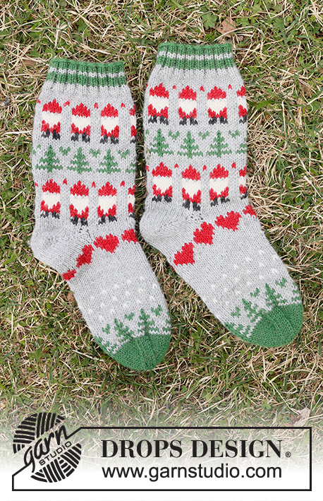Christmas Time Socks / DROPS Children 44-20 - Gebreide sokken voor kinderen in DROPS Karisma. Het werk wordt van boven naar beneden gebreid met gekleurd patroon van kerstman, kerstboom en hartje. Maten 24 – 43. Thema: Kerst.