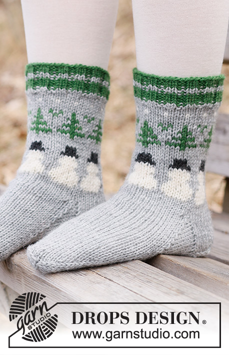 Snowman Time Socks / DROPS Children 44-21 - Gebreide sokken voor kinderen in DROPS Karisma. Het werk wordt van boven naar beneden gebreid met sneeuwpop en kerstboom patroon. Maten 24 – 43. Thema: Kerst.