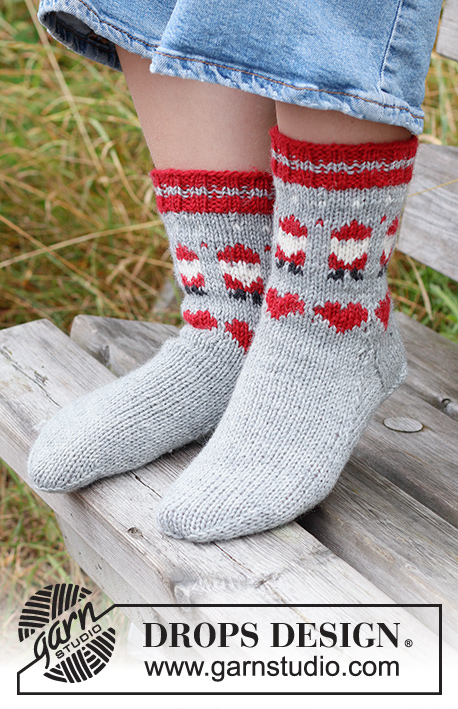 Santa Time Socks / DROPS Children 44-22 - Strikkede sokker til barn i DROPS Karisma. Arbeidet strikkes ovenfra og ned i flerfarget mønster med nisse og hjerte. Størrelse 24 – 43. Tema: Jul.