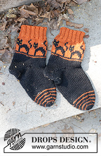 Spooky Sunset Socks / DROPS Children 47-29 - Gebreide sokken voor kinderen in DROPS Karisma. Het werk wordt gebreid vanaf de teen in de hoogte, met een meerkleurig patroon met katten en wighak. Maten 35-43. Thema: Halloween.